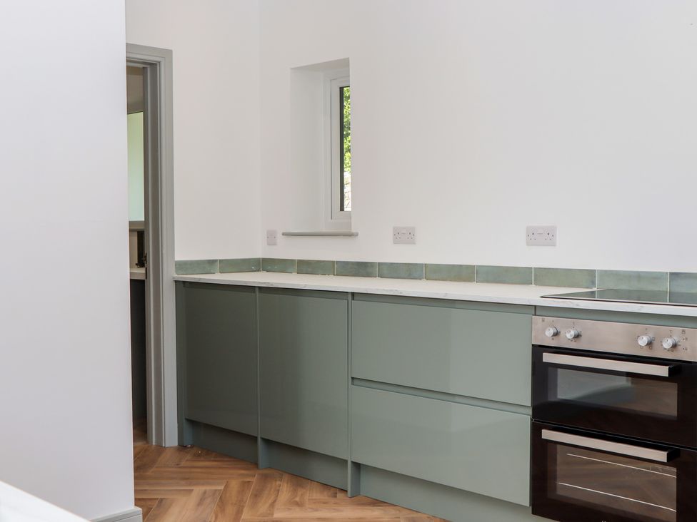 A kitchen with cabinets and an oven at Seacroft in Torquay