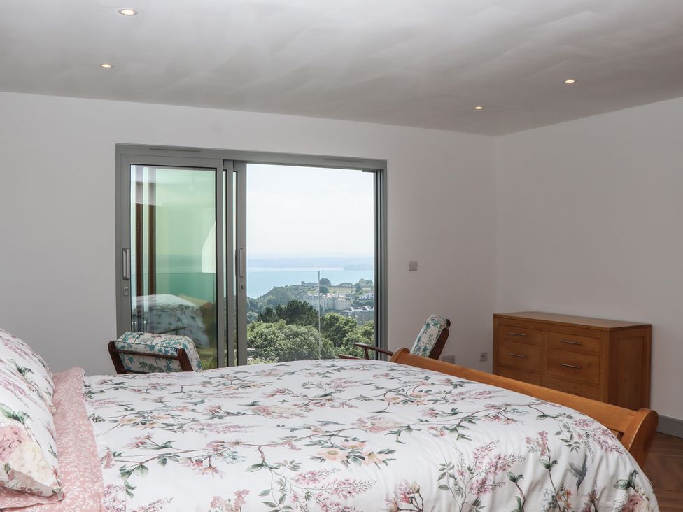 A bedroom with a bed and dresser at Seacroft in Torquay