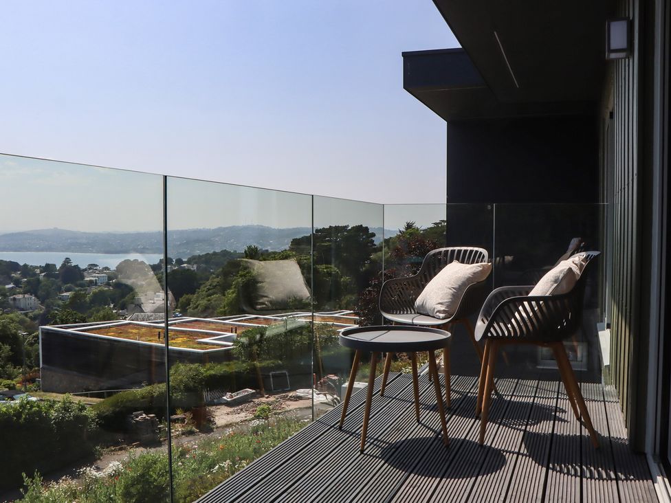 A balcony with chairs and a table at Seacroft in Torquay