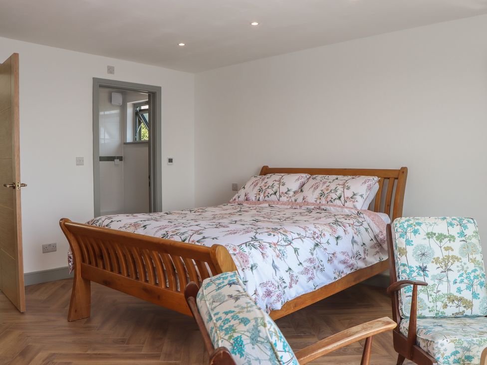 A bedroom with a bed and chair at Seacroft in Torquay