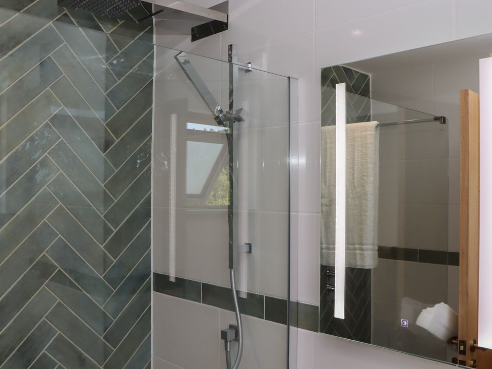 A bathroom with a shower and mirror at Seacroft in Torquay