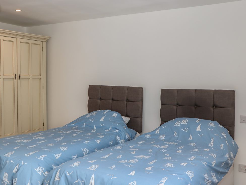 A bedroom with two beds and a wardrobe at Seacroft in Torquay