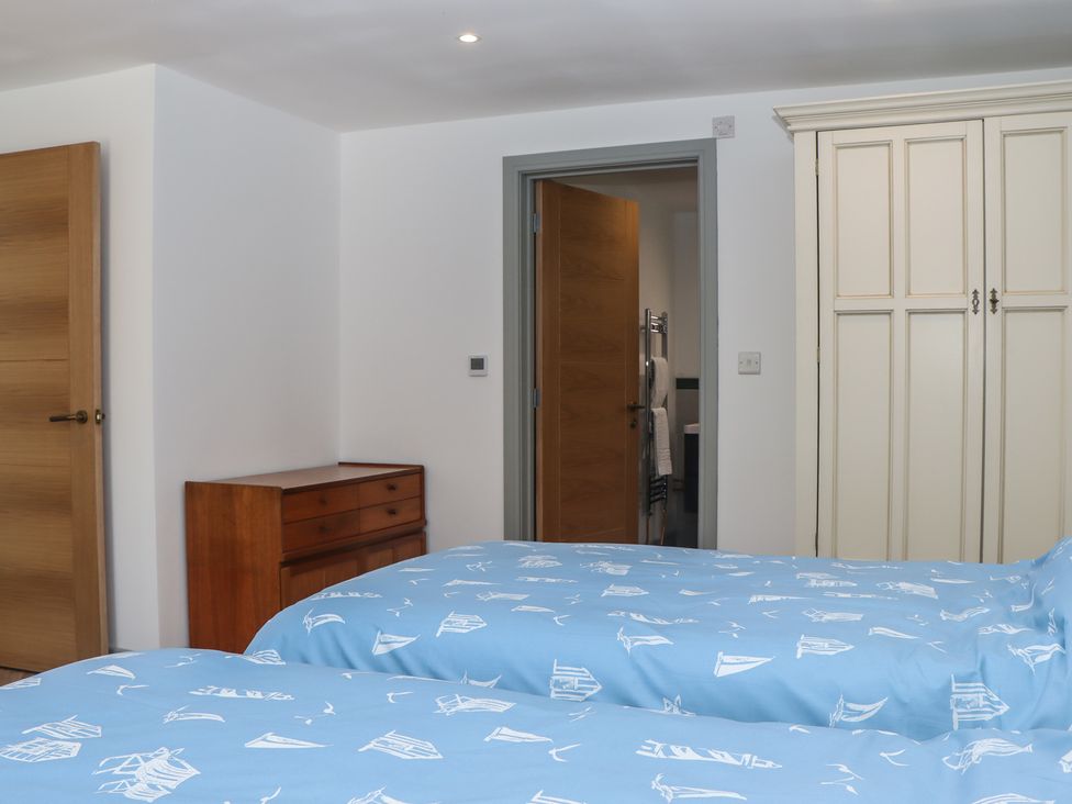 A bedroom with two beds and a wardrobe at Seacroft in Torquay