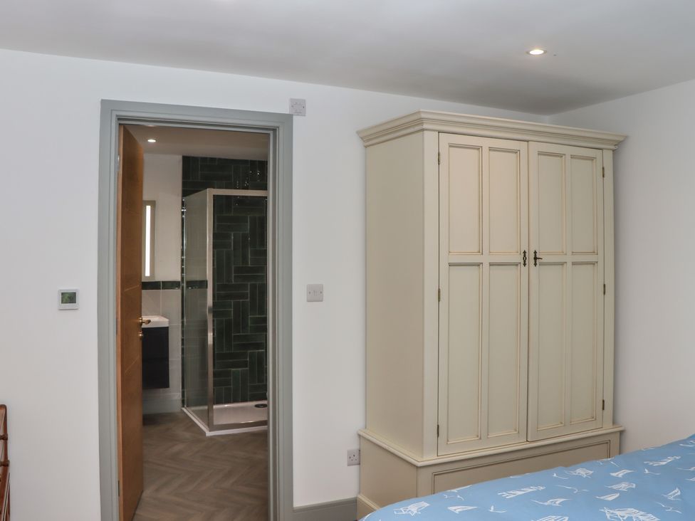 A bedroom with a wardrobe and bathroom door at Seacroft in Torquay