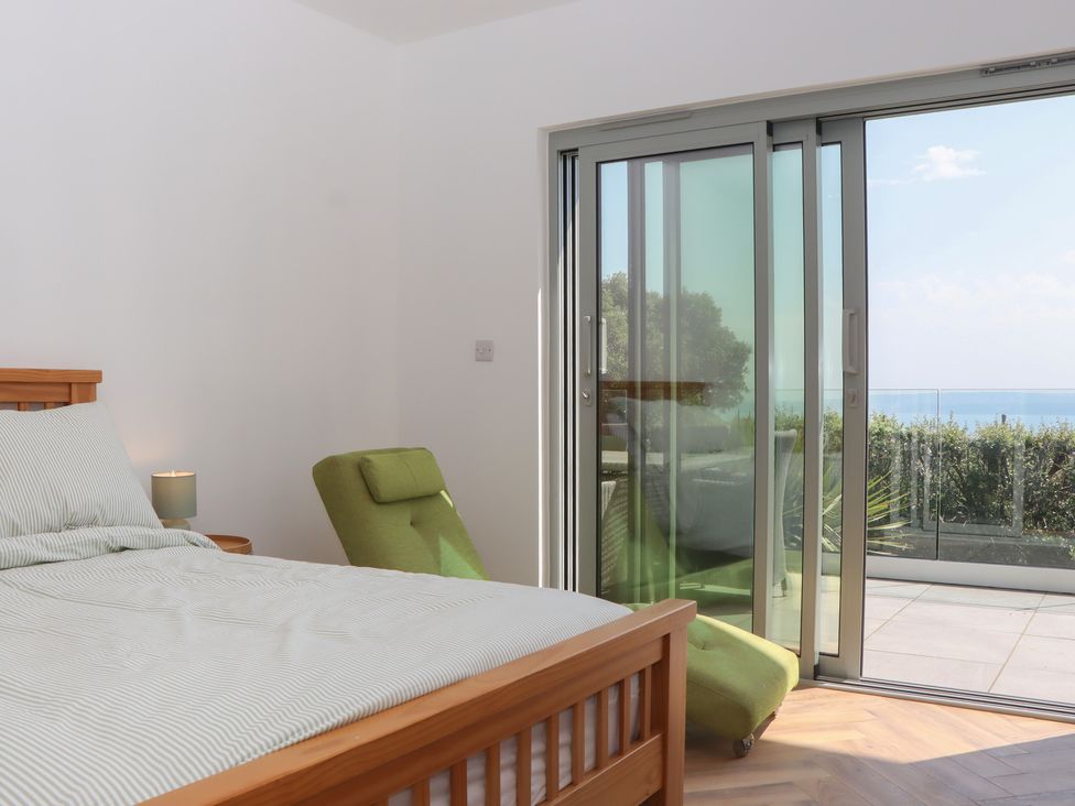 A bedroom with a bed and sliding doors at Seacroft in Torquay