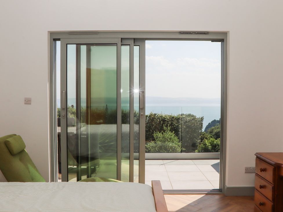 A bedroom with a sliding door leading to a patio at Seacroft in Torquay