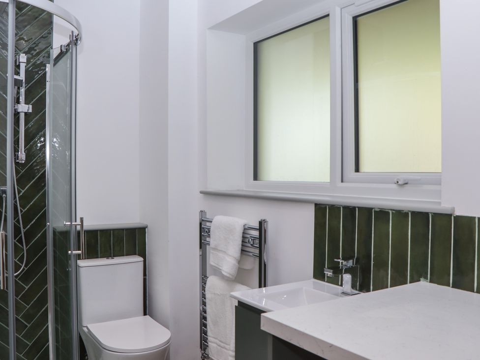 A bathroom with a shower, toilet, and sink at Seacroft in Torquay
