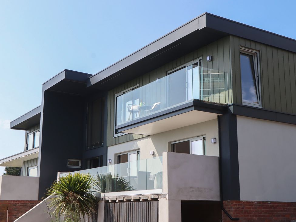 A modern building with glass balcony and windows at Seacroft in Torquay