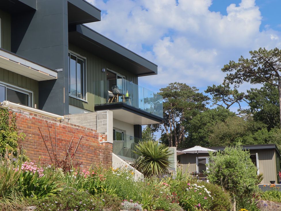 An outdoor view of a building with a balcony and garden at Seacroft in Torquay