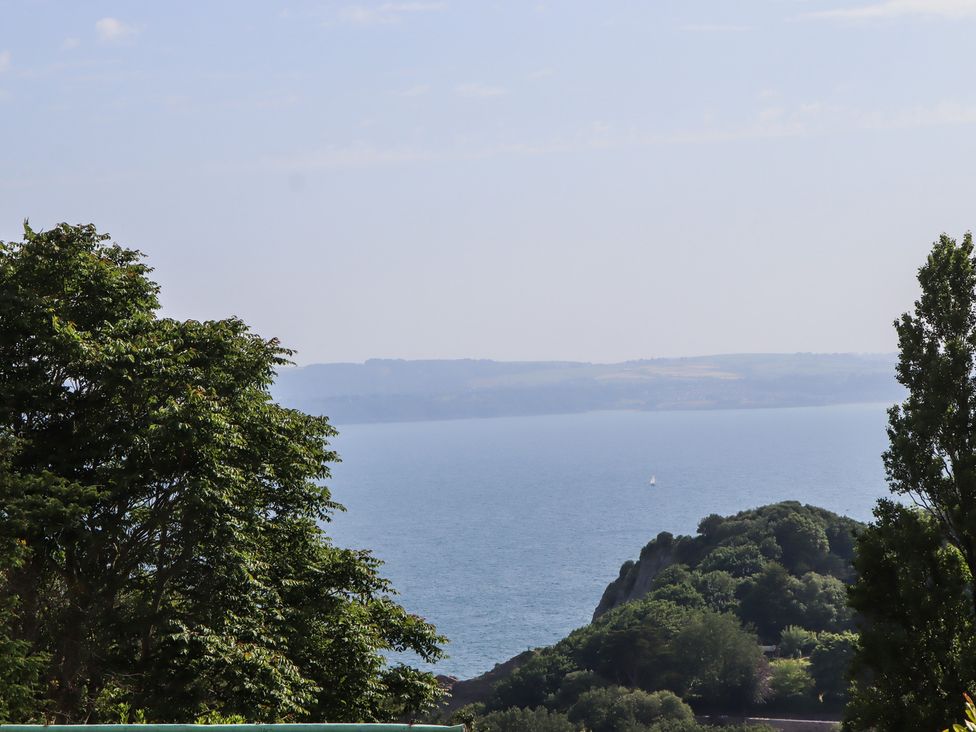 A view of the sea and hills with trees at Seacroft in Torquay