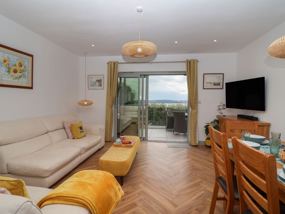 A living room with a sofa and dining area at Seacroft in Wellswood near Torquay
