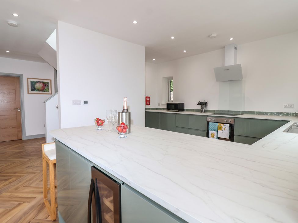 A kitchen with a marble island and appliances at Seacroft in Wellswood near Torquay