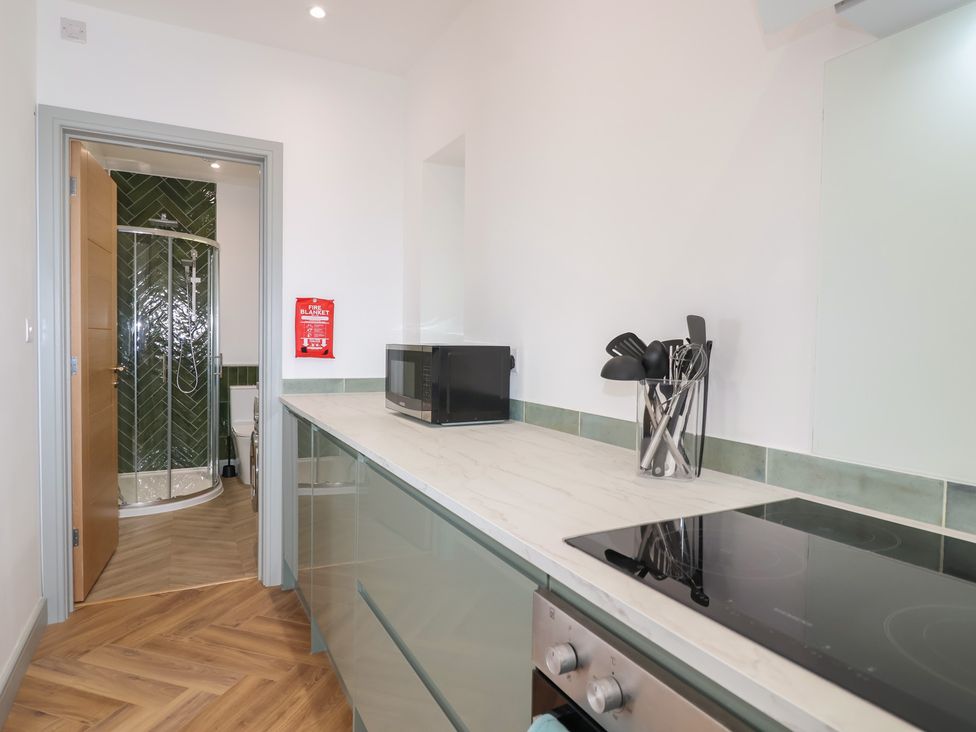 A kitchen with a microwave and cooking utensils at Seacroft in Wellswood near Torquay