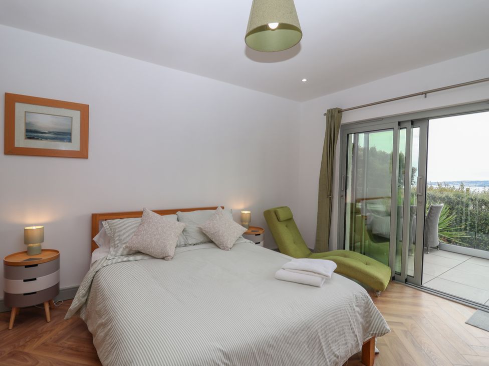 A bedroom with a bed and sliding door at Seacroft in Wellswood near Torquay
