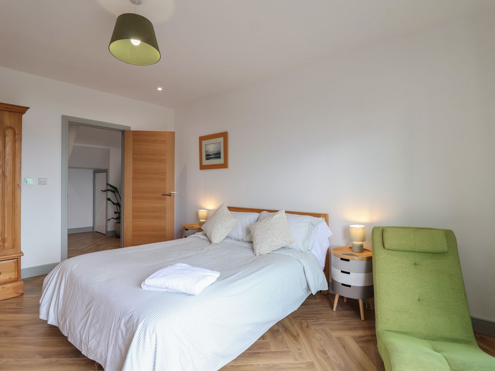 A bedroom with a bed and nightstand at Seacroft in Wellswood near Torquay
