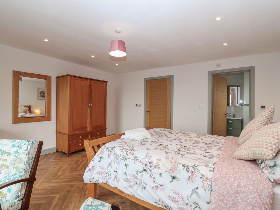 A bedroom with a bed and wardrobe at Seacroft in Wellswood near Torquay