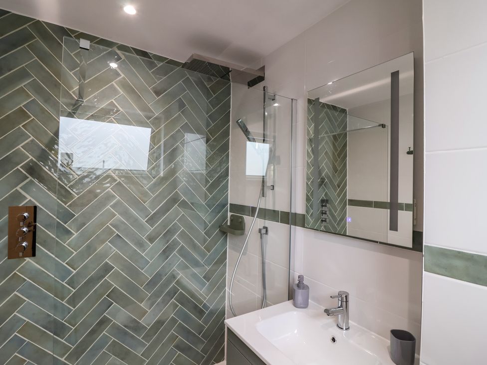 A bathroom with a shower and sink at Seacroft in Wellswood near Torquay