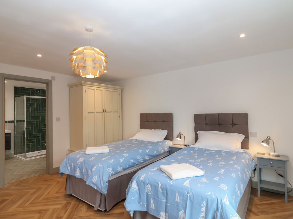 A bedroom with two beds and a wardrobe at Seacroft in Wellswood near Torquay