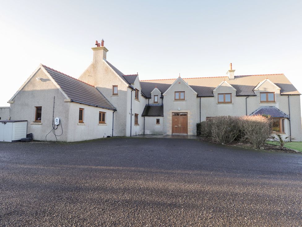A house with a driveway and bushes at Northbanks House in Thurso