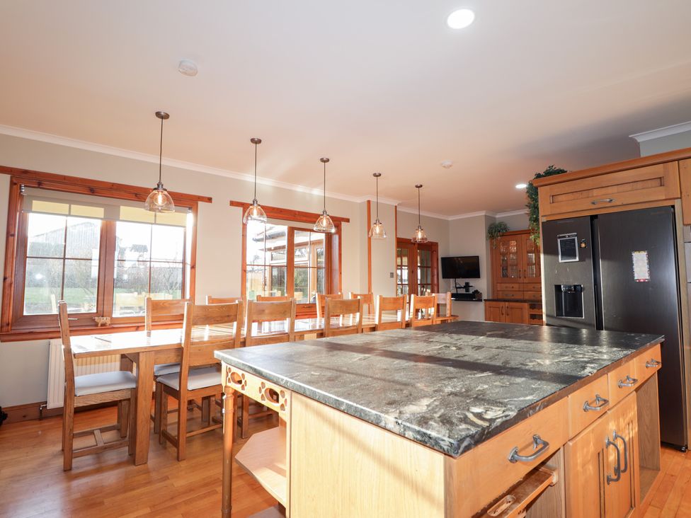 A kitchen with wooden furniture and a cooking island at Northbanks House Thurso