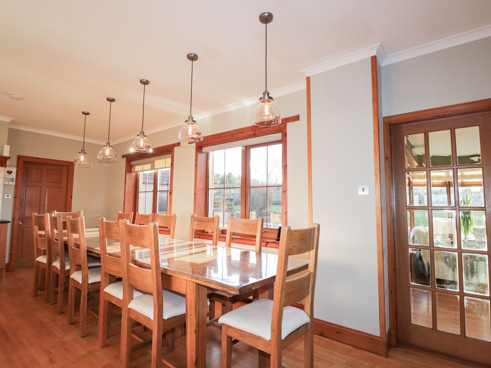 A dining room with a long table and chairs at Northbanks House in Thurso
