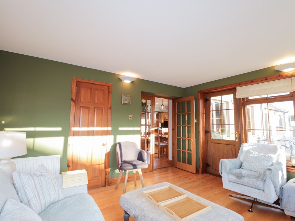 A living room with a sofa and armchair at Northbanks House Thurso