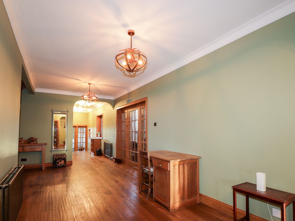 A hallway with a desk and mirrors at Northbanks House in Thurso