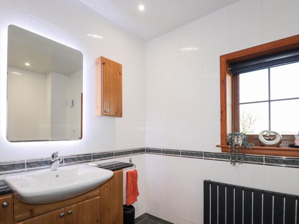 A bathroom with a sink and mirror at Northbanks House in Thurso