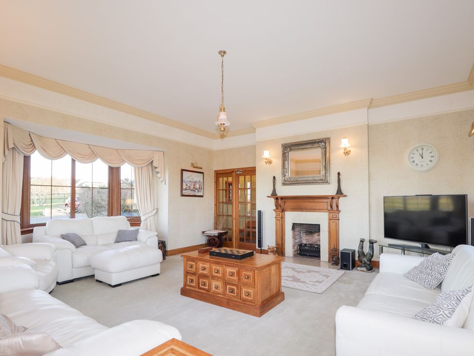 A living room with sofas, a coffee table, and a fireplace at Northbanks House in Thurso