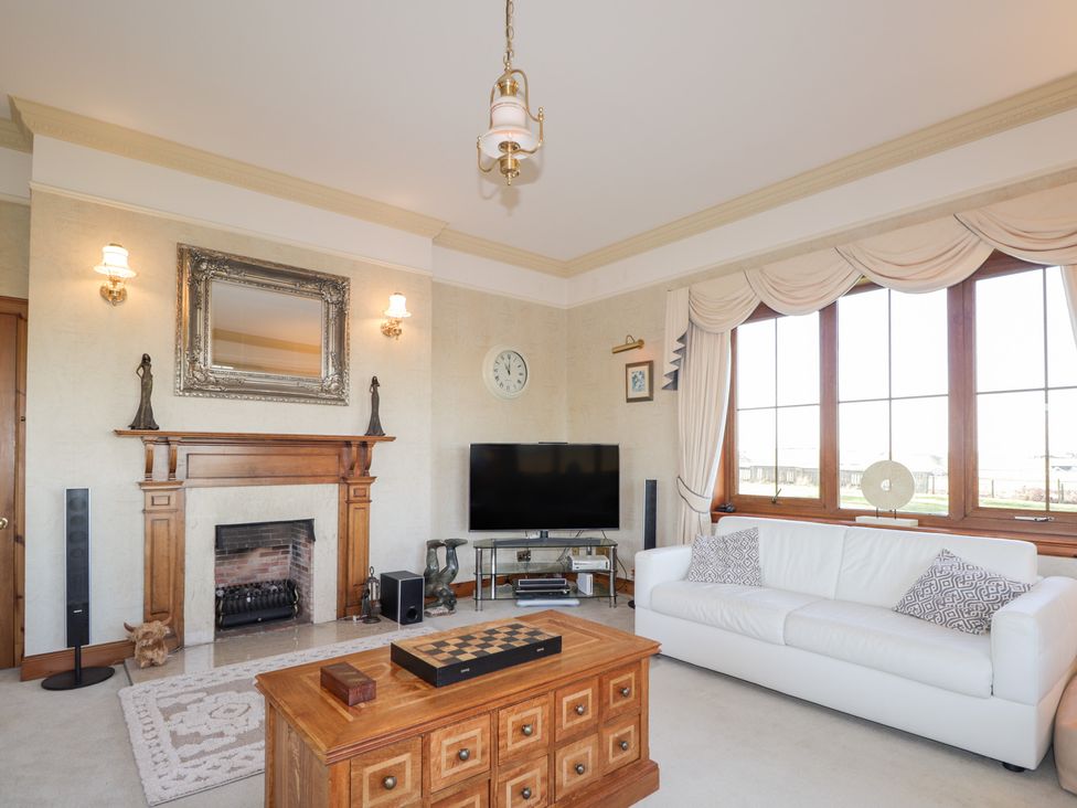 A living room with a fireplace and a television at Northbanks House Thurso