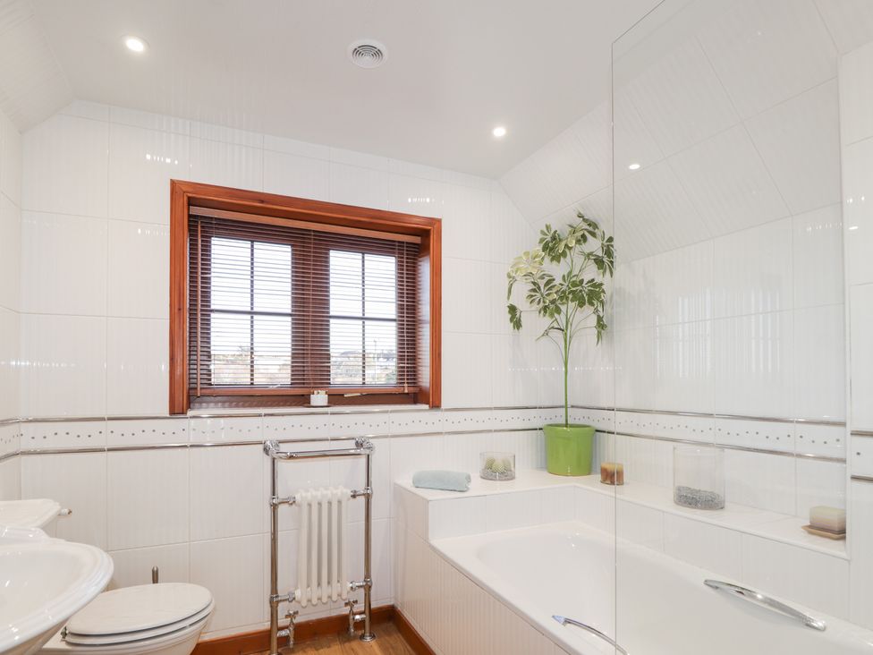 A bathroom with a bathtub, sink, and toilet at Northbanks House in Thurso
