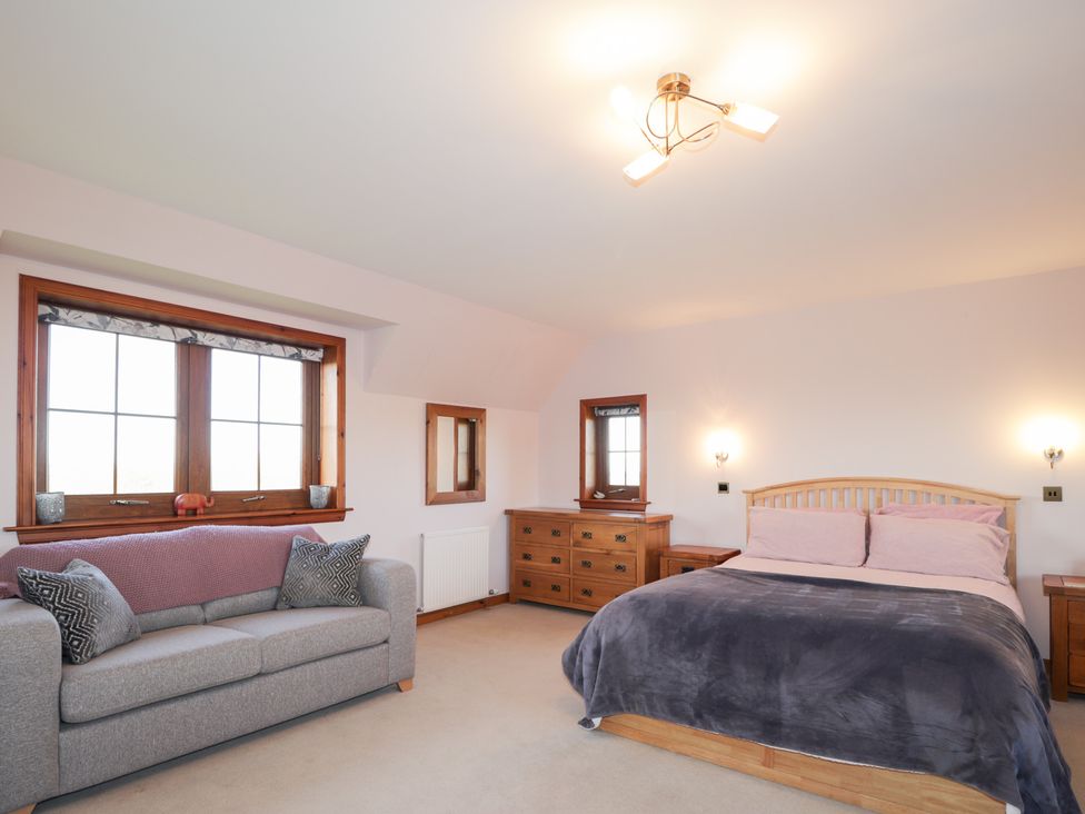 A bedroom with a bed and sofa at Northbanks House in Thurso