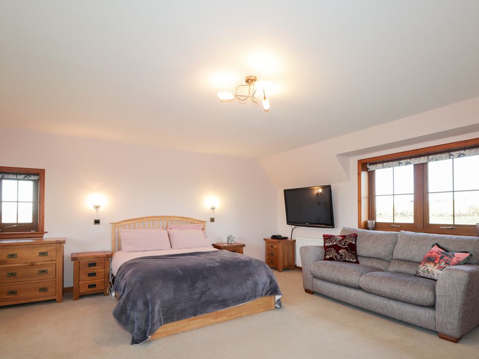 A bedroom with a bed and sofa at Northbanks House Thurso