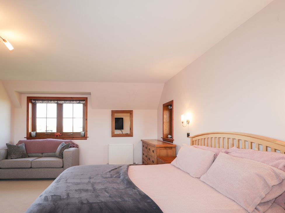 A bedroom with a bed and a sofa at Northbanks House in Thurso