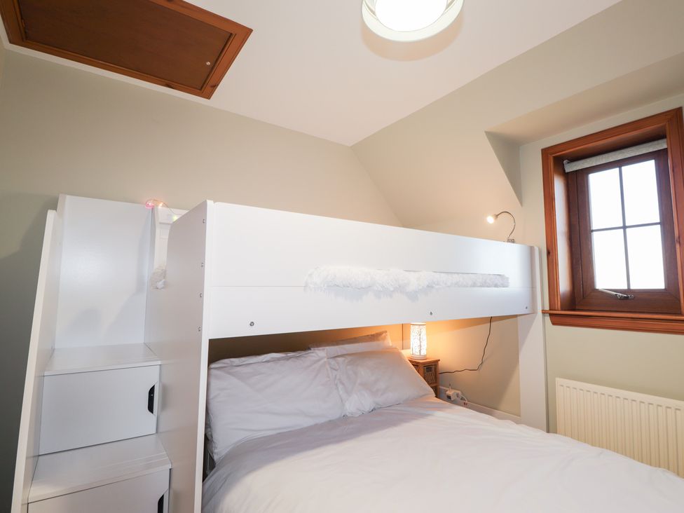 A bunk bed with white bedding and a window at Northbanks House Thurso