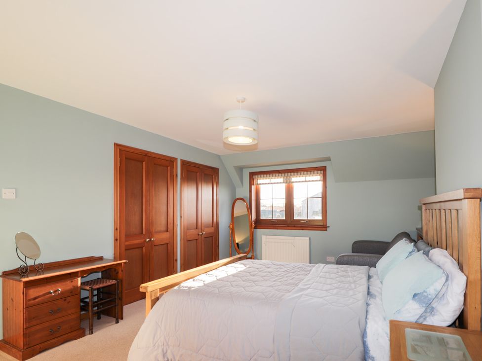 A bedroom with a bed, desk, and mirror at Northbanks House Thurso