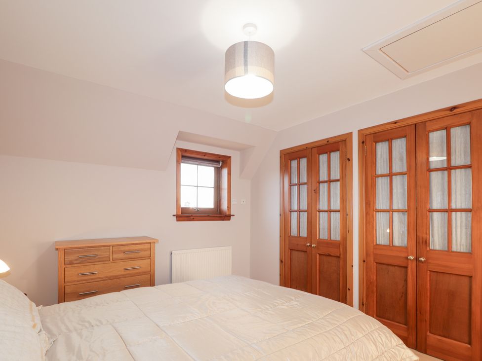 A bedroom with a bed and a chest of drawers at Northbanks House in Thurso