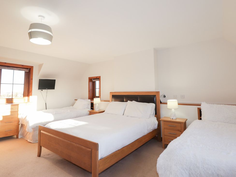 A bedroom with two beds and a television at Northbanks House Thurso
