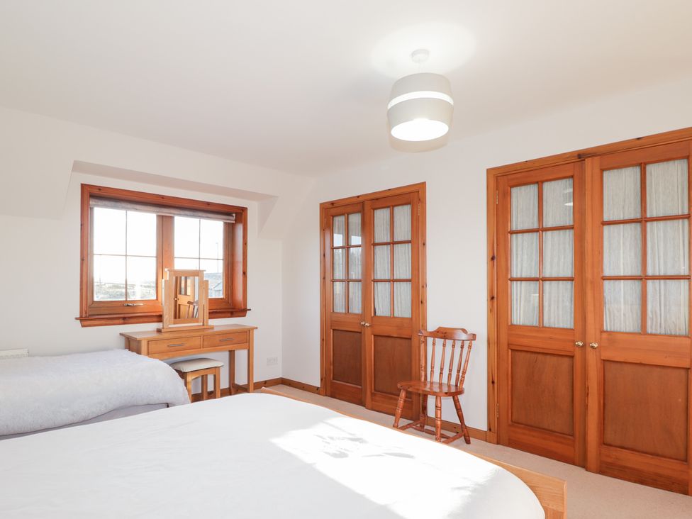 A bedroom with a bed, desk, chair, and window at Northbanks House Thurso