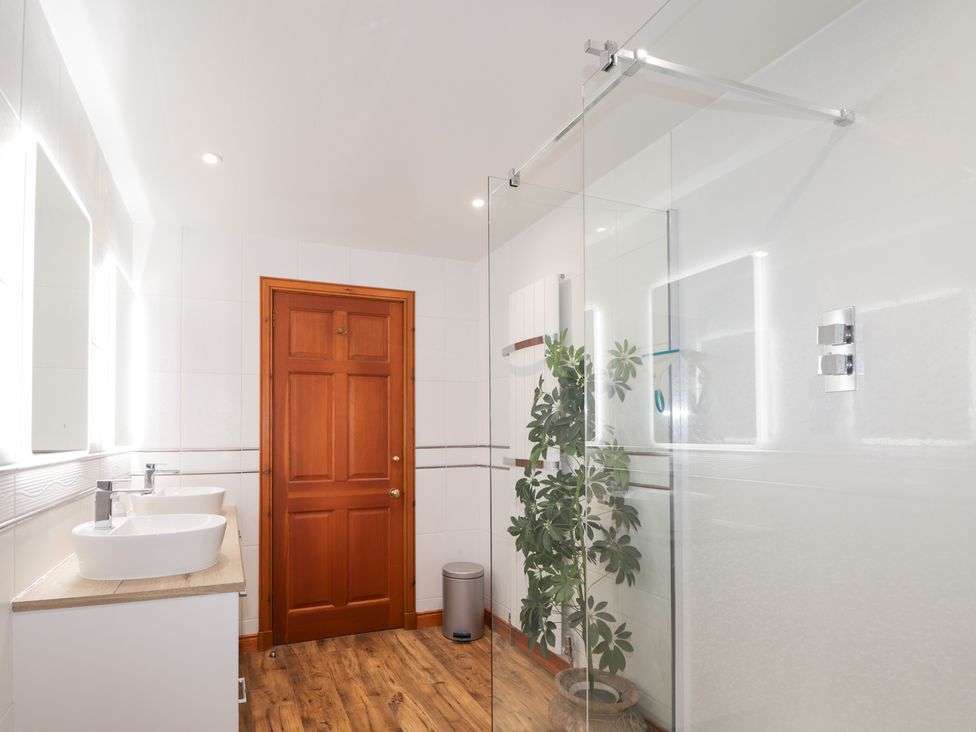 A bathroom with sinks and a shower at Northbanks House in Thurso