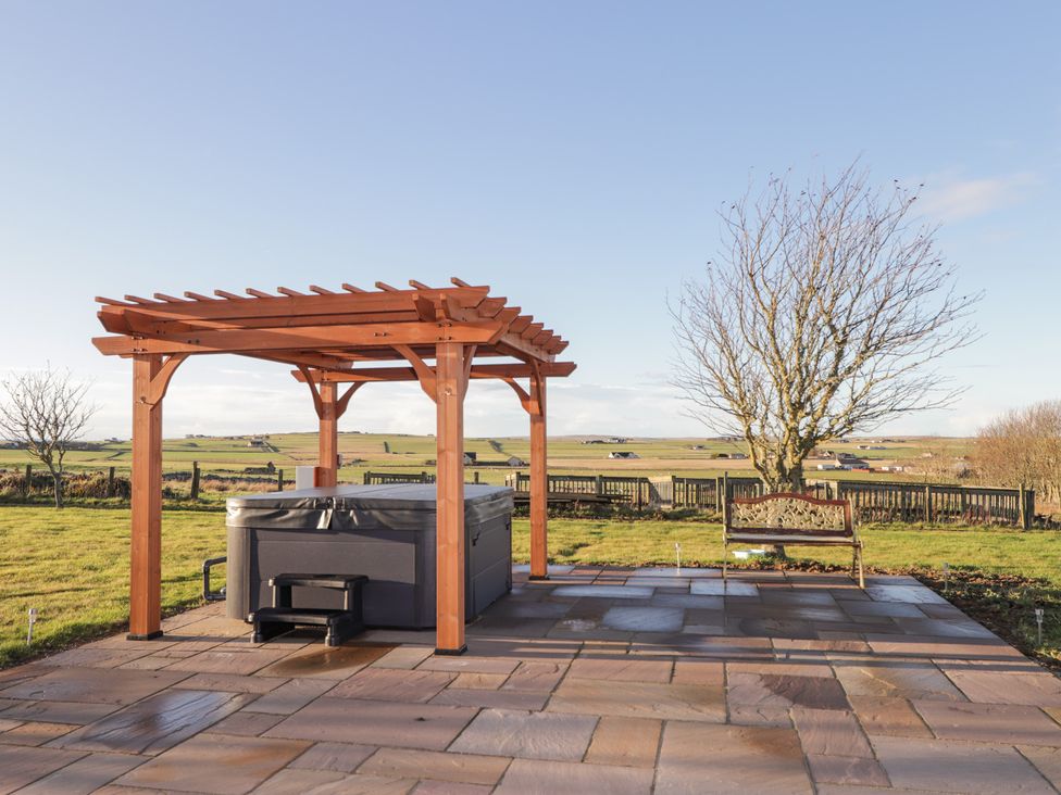An outdoor area with a hot tub under a pergola at Northbanks House Thurso
