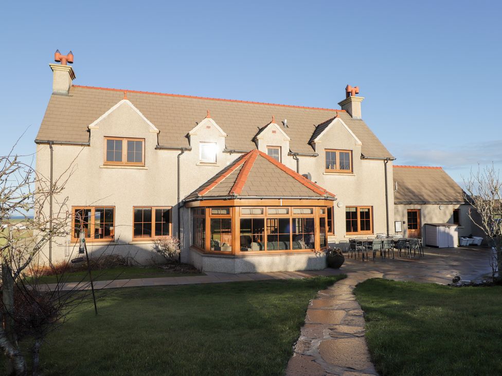 A house with a garden and outdoor seating area at Northbanks House in Thurso