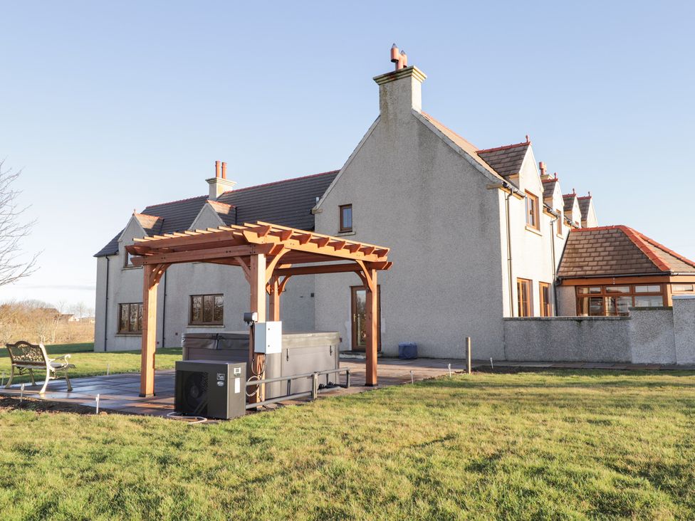 An outdoor area with a hot tub and a pergola at Northbanks House in Thurso