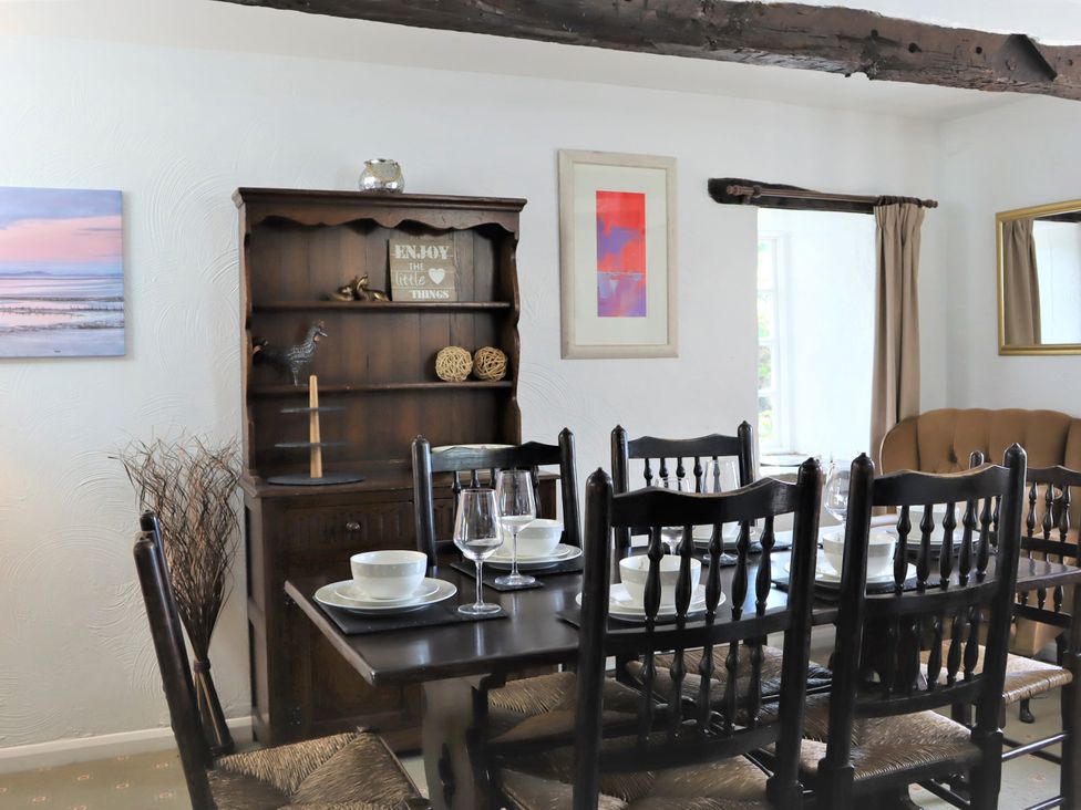 A dining room with a table set and shelves at The Little Farmhouse in Carnforth