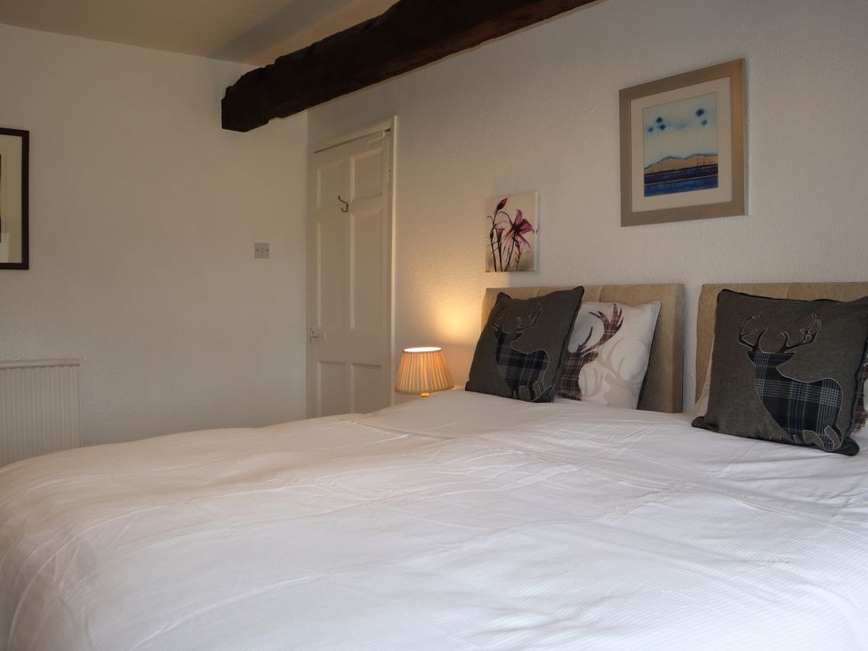 A bedroom with a bed and wall art at The Little Farmhouse in Carnforth