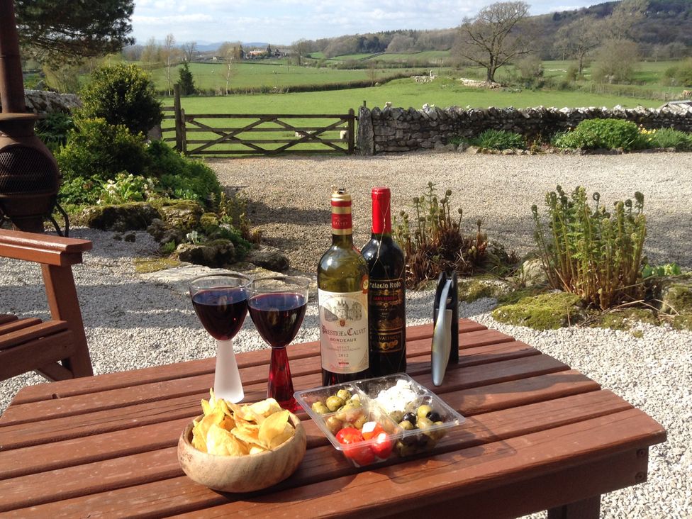 A table with wine glasses and snacks at The Little Farmhouse in Carnforth