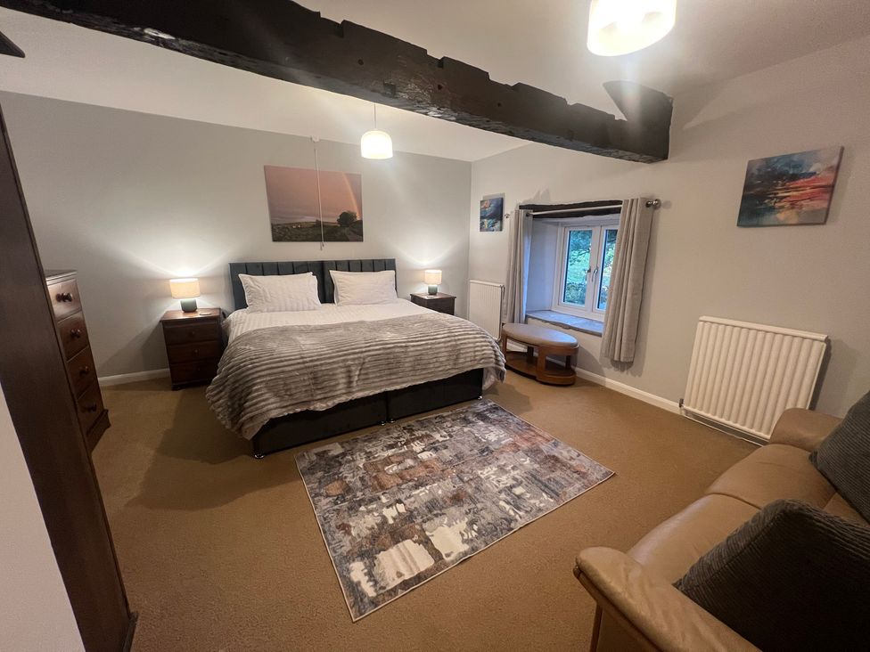 A bedroom with a double bed and a window at The Old Farmhouse at Brackenthwaite Farm in Yealand Redmayne near Arnside