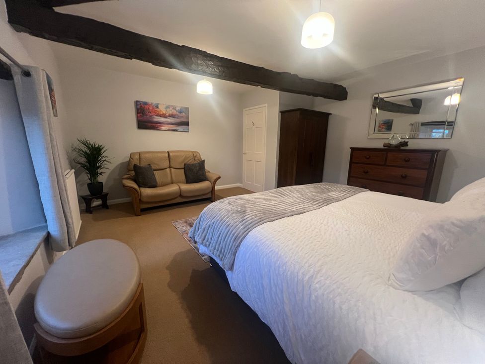 A bedroom with a bed and sofa at The Old Farmhouse at Brackenthwaite Farm Yealand Redmayne near Arnside