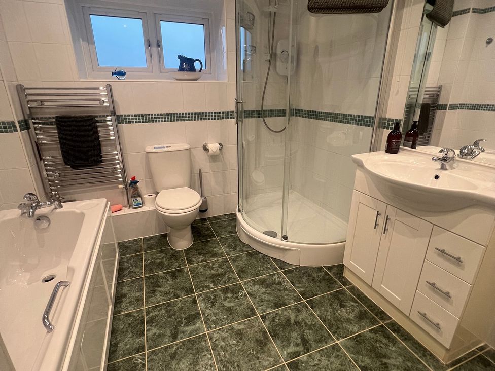 A bathroom with a bathtub, shower, toilet, and sink at The Old Farmhouse at Brackenthwaite Farm Yealand Redmayne near Arnside