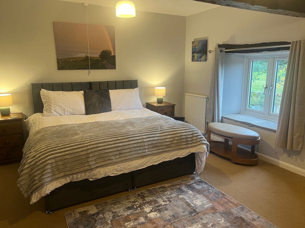 A bedroom with a bed and bedside tables at The Old Farmhouse at Brackenthwaite Farm near Arnside